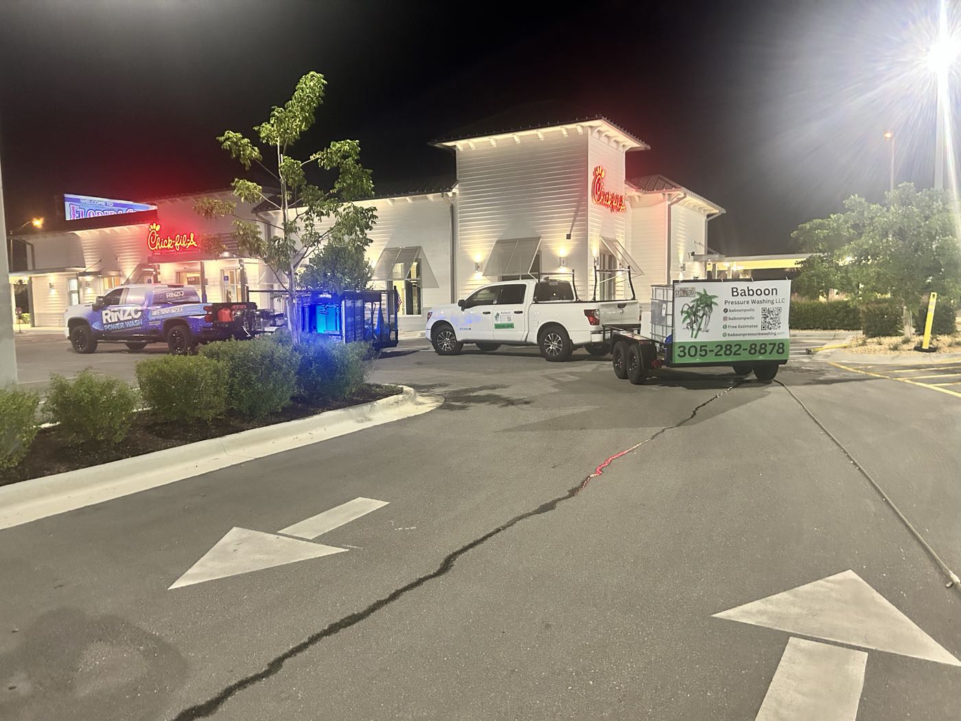 The Baboon Pressure Washing truck and trailer rig parked outside a Chick-fil-A restaurant at night